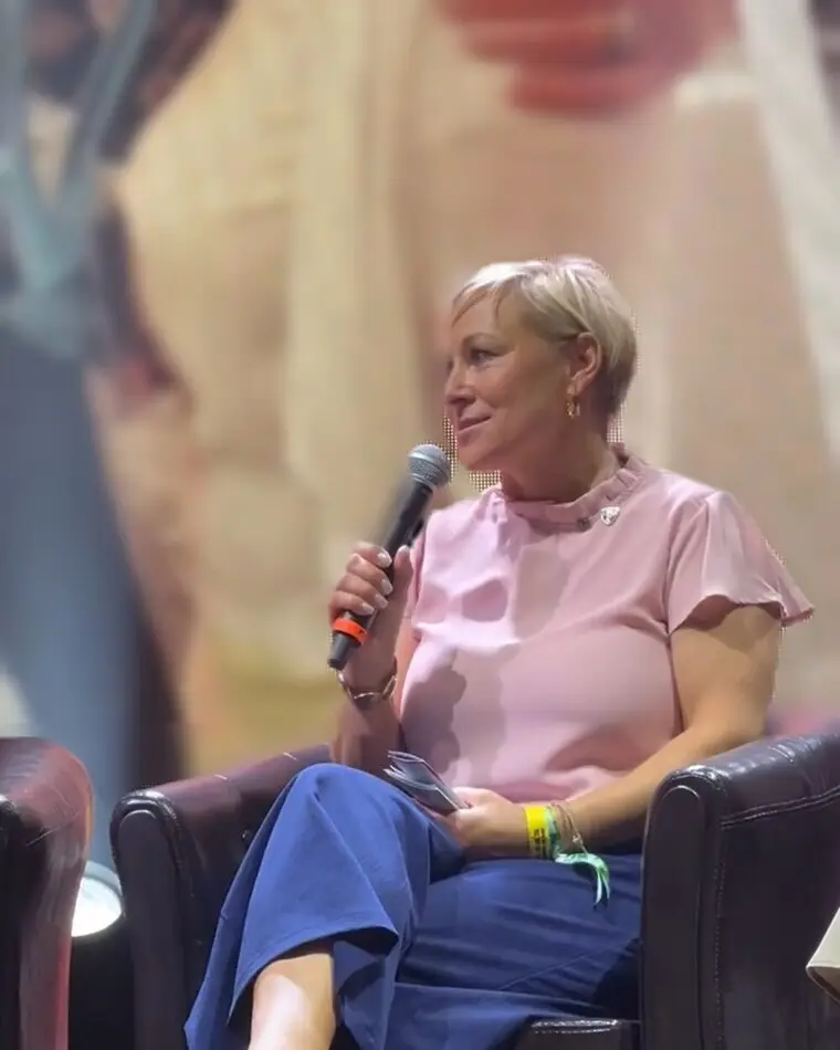 Heike Berndt spricht 2025 mit Mikrofon auf einer Bühne